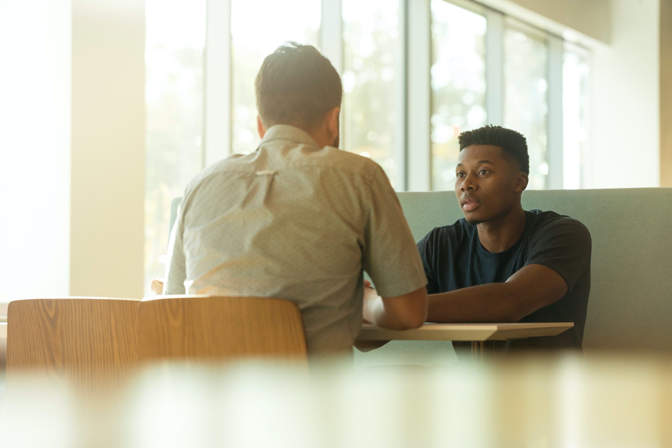 Two people having a conversation at a table.
